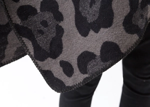 Close-up of leopard print pattern and knitted fabric texture on gray and black shawl