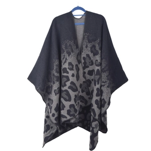 Detail of leopard print knit poncho shawl with geometric patterns and fringe hem