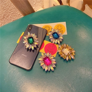 Detail view of retro crystal gemstone phone grips in emerald, blue, rose, and champagne colors