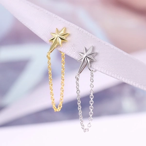 Macro shot of gold and silver S925 sterling silver star earrings with tassel chains
