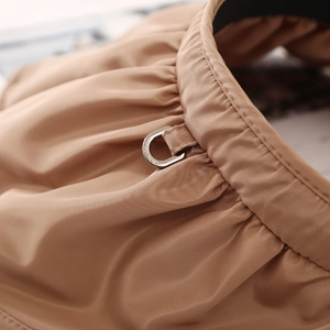 Detail of khaki shell hat featuring a silk-textured pleated band and silver metal D-ring