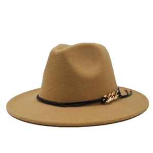 Dettaglio di cappello fedora in lana cammello con cordino nero e catena d'oro