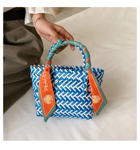 Détail d'un sac à main tissé avec motif géométrique bleu et blanc et foulard décoratif