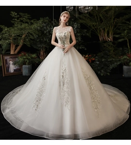 Close-up of intricate floral lace embroidery and sequins on the white bridal gown