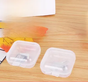 Mini transparent plastic storage boxes for jewelry and SIM cards on a wooden table