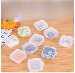 Flat lay of multiple small square clear plastic organizer boxes on wooden surface
