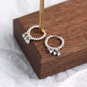 Close-up of S925 sterling silver beaded hoop earrings with three zircon tassel charms