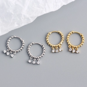 Close-up of gold and silver S925 sterling silver hoop earrings with three zircon tassels