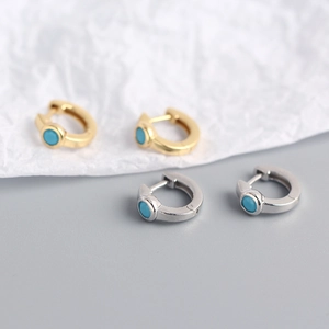 Macro detail of gold and silver S925 sterling silver hoop earrings with blue turquoise stones