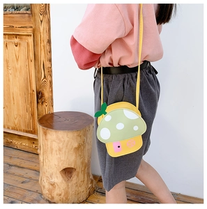 Toddler mushroom house cross body bag with long strap shown on model outdoors