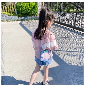 Detailed close-up of a child wearing a mushroom-shaped silicone crossbody bag in outdoor setting