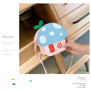 Close-up of cute mushroom-shaped kids' crossbody bag with blue polka dot cap and pink base