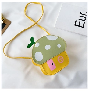 Detailed top view of a yellow mushroom-shaped kid bag with green polka dot lid on white fabric