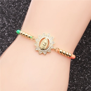 Dettaglio del bracciale intrecciato con ciondolo della Vergine Maria e zirconi pavé