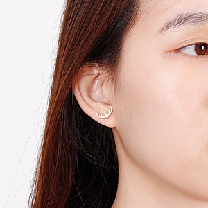 Elegante goldene Rentier-Geweih-Ohrstecker getragen von einem Model für einen schicken Look