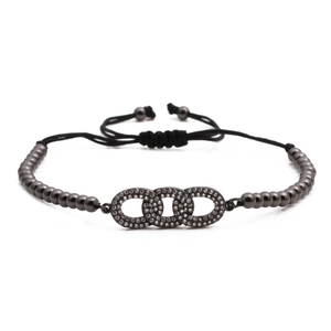 Adjustable dark grey beaded bracelet with three interlocking rhinestone circles on white background
