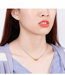 Nahaufnahme eines Modells mit minimalistischem goldenem Rentiergeweih Halskette und Ohrring Set