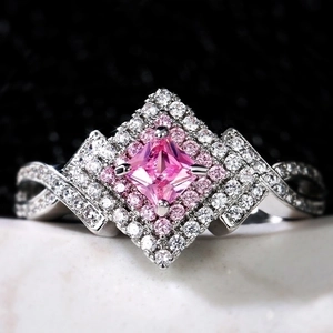 Luxurious pink sapphire crossover ring with double halo diamond setting in silver finish
