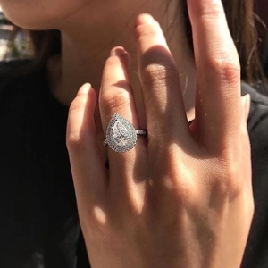 Elegant pear-shaped teardrop zircon ring with halo double setting and pave band on hand