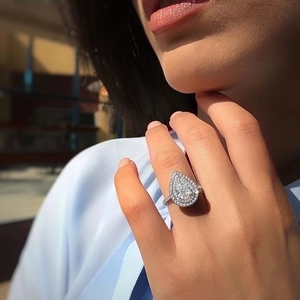 Elegant pear-shaped halo zircon ring with pave band shown on a model's hand