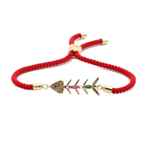Adjustable red rope bracelet featuring a gold fishbone charm with colorful zircon inlay