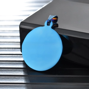 Macro view of a bright blue circular pet ID tag with a rainbow-finish metal jump ring