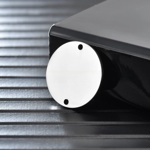 Macro view of double-hole round stainless steel tag with mirror-polished silver finish