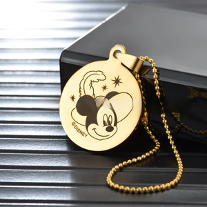 Detailed close-up of a golden Mickey Mouse engraved stainless steel pet ID tag and bead chain