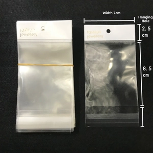 Detailed view of clear OPP adhesive bag with white header and gold jewelry lettering