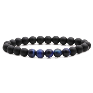 Detail of matte black beads and blue tiger eye stones on an elastic beaded bracelet
