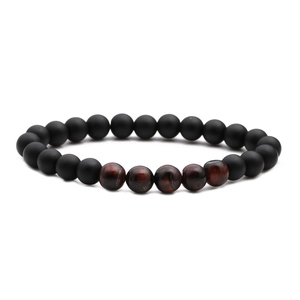 Macro shot of matte black and polished tiger eye beads on a handmade beaded bracelet
