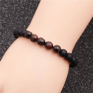 Detail of 8mm matte black beads and polished red tiger eye stones on a beaded bracelet