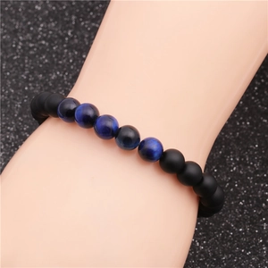 Close-up of beaded bracelet with polished blue tiger eye and matte black stones