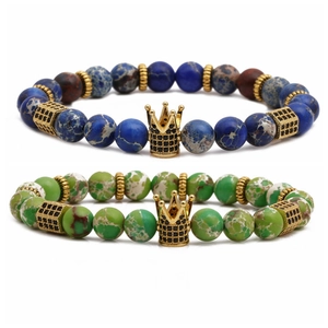 Braided bead bracelet set with turquoise stones and golden crown charm on white background