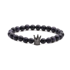 Blue sand stone faceted bead bracelet with a silver crown charm on a white background