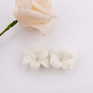 Detailed view of white 3D resin flower earrings for DIY crafts on a white background