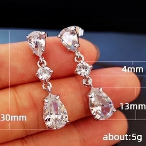 Teardrop cubic zirconia drop earrings in silver finish showing 30mm length scale