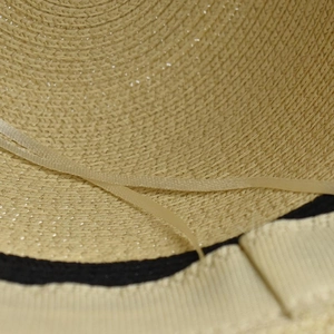 Women's straw bucket hat interior showing dual-tone sweatband and adjustable drawstring