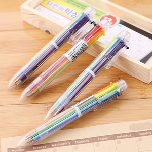 Transparent 6-in-1 multi-colored retractable ballpoint pens on a wooden desk setup