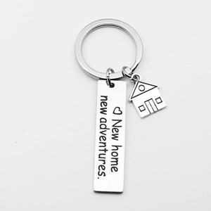 Detail showing 'New home new adventures' engraved keychain with a small house charm