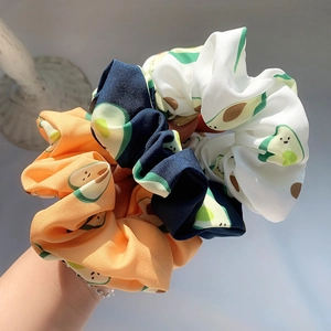 Three-piece avocado print hair scrunchies in orange, navy and white fabric
