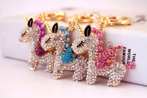 Detailed view of three sparkling crystal unicorn keychains in purple, blue and pink wings