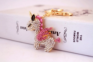 Detail of crystal unicorn keychain with pink and white rhinestones on a gold base