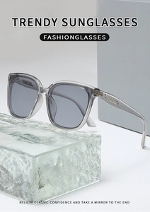Close-up of translucent grey square sunglasses frame with metallic temple detail