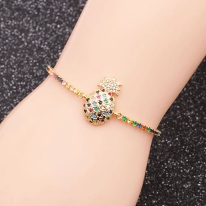 Golden pineapple charm bracelet with colorful rainbow zircons on a model's wrist