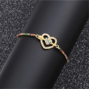 Adjustable gold heart bracelet with colorful cubic zirconia stones on display stand