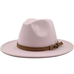 Close-up detail of a pink woolen fedora hat with a brown leather belt buckle band.