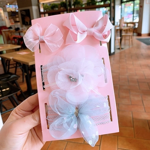 Detail view of 4-piece baby headband gift set featuring pink bows and floral accessories