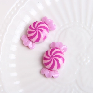 Detailed view of pink and white spiral resin candy charms on a decorative tray