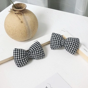 Gros plan détaillé de nœuds en tissu à carreaux noir et blanc pour accessoires de cheveux
